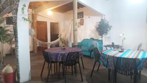 a dining room with two tables and a blue couch at Hostal Villa Brisa in Ballenita