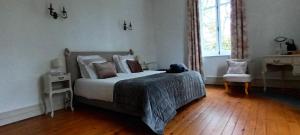 a bedroom with a bed and a chair and a window at Petit manoir de la berthenlaire in Baincthun
