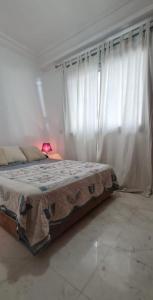 a bed in a room with white curtains at Dar sam in Tangier +14 photos