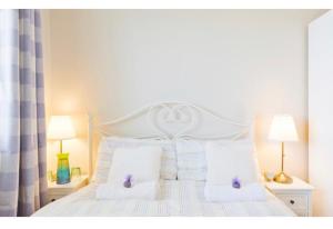 a white bed with two white pillows and two lamps at Modern Homestay 15 minutes to Dublin Airport in Ballyboughal