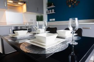 a dining table with wine glasses and plates on it at Stylish House with Private parking in Glasgow