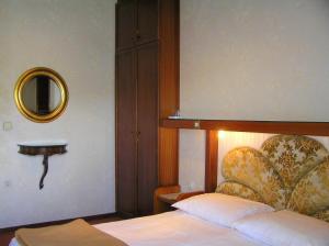 a bedroom with a bed with a headboard and a mirror at Guest House Lifestyle Holiday in Opatija
