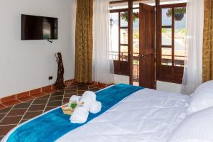 a bedroom with a bed with towels on it at HOTEL ENCANTO COLONIAL in Villa de Leyva