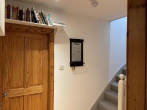 ein Zimmer mit einer Treppe, einem Bücherregal und einer Tür in der Unterkunft 1 Keepers Cottage Skeabost Bridge Isle Of Skye in Skeabost