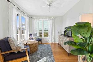 a living room with a tv and a blue chair at Saltans of Swing Brunswick Vacation Rentals in Holden Beach
