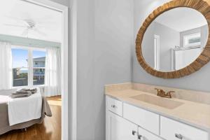 a bathroom with a sink and a mirror at Saltans of Swing Brunswick Vacation Rentals in Holden Beach +42 photos