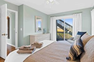 a bedroom with a bed with towels on it at Saltans of Swing Brunswick Vacation Rentals in Holden Beach