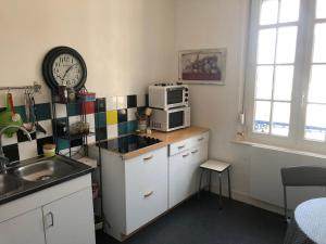 een keuken met een wastafel en een magnetron op een aanrecht bij villa stella in Ault