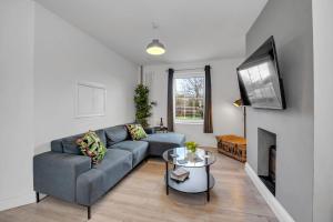a living room with a blue couch and a fireplace at End of Terrace 3 bedroom House with Garden in Newmarket