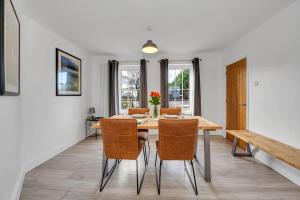 uma sala de jantar com uma mesa de madeira e cadeiras em End of Terrace 3 bedroom House with Garden em Newmarket