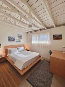 1 dormitorio con 1 cama blanca grande y cabecero de madera en Akule Clubhouse, en Waialua