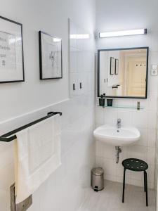 a white bathroom with a sink and a mirror at Mikszáth Apartments Budapest in Budapest