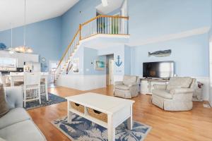 a living room with a white table and chairs at Rip Tide I Brunswick Vacation Rentals in Sunset Beach