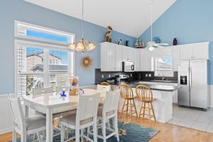 a kitchen with a table and chairs and a refrigerator at Rip Tide I Brunswick Vacation Rentals in Sunset Beach