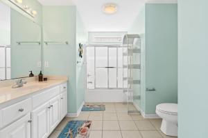 a bathroom with a sink and a toilet and a shower at Rip Tide I Brunswick Vacation Rentals in Sunset Beach +41 photos