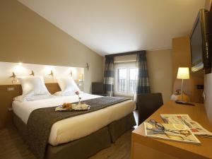 a hotel room with a large bed and a table at Hotel Porta Nuova in Assisi