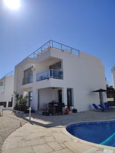 een wit gebouw met een balkon en een zwembad bij 3 Bedroom Coral Bay Panorama Seaview Villa Pool in Coral Bay