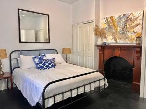 a bedroom with a bed with a fireplace and a mirror at 1880 Cottage in Tumut