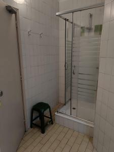 y baño con ducha y taburete verde. en Aliados City Drop Private Room, en Oporto