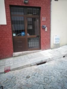 un edificio de ladrillo con una puerta marrón en una calle en Aliados City Drop Private Room, en Oporto