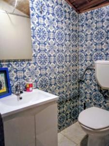 baño con aseo y azulejos azules y blancos en Aliados City Drop Private Room, en Oporto