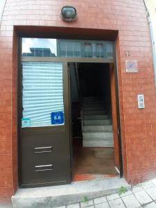 una entrada a un edificio de ladrillo con puerta y escaleras en Aliados City Drop Private Room, en Oporto