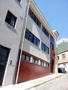 un edificio de apartamentos con garaje de ladrillo rojo en Aliados City Drop Private Room, en Oporto