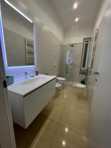 ein Badezimmer mit einem großen weißen Waschbecken und einem WC in der Unterkunft MAKI HOME in Portici