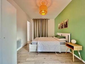 - une chambre avec des murs verts, un lit et une table dans l'établissement Havre de paix à 20 min de Nice, à Contes