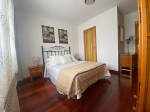 a bedroom with a bed and a wooden floor at hospedaje casa milagros in Santillana del Mar