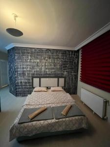 a bedroom with a large bed and a brick wall at Trendhouse in Ankara