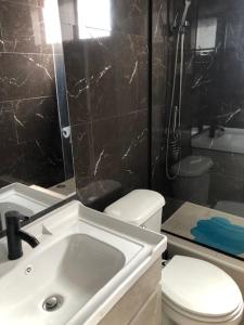 a bathroom with a toilet and a sink and a shower at departamento Iquique in Iquique