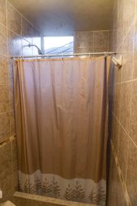 a shower with a shower curtain in a bathroom at Hotel Nativa in Chivay