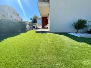 un cortile con prato verde e un edificio di Casa Fralia a Olbia