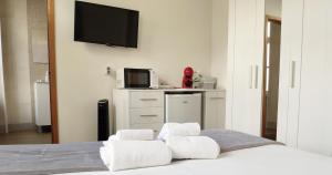a bedroom with a bed with towels on it at Casa do Recanto - Private Suite in Porto