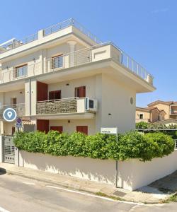 - un bâtiment blanc avec un balcon au-dessus dans l'établissement Casa Fralia, à Olbia