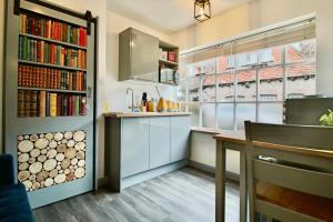 a kitchen with a table and a book shelf with books at Alfriston Lodge By Air Premier in Alfriston