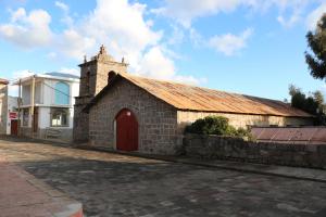 un antiguo edificio de ladrillo con una puerta roja en SUNSET Lodge Amantani, en Ocosuyo