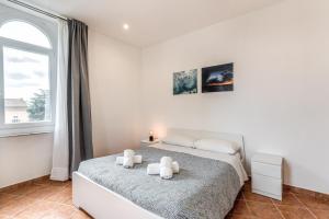 ein weißes Schlafzimmer mit einem Bett und einem Fenster in der Unterkunft V E N E R E Apartments in Rom