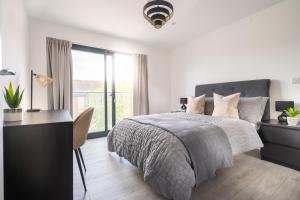 a bedroom with a bed and a desk and a window at Oasis at Hemel Hempstead in Hemel Hempstead