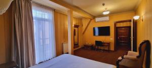 a hotel room with a bed and a television at Topaz Boutique in Cluj-Napoca