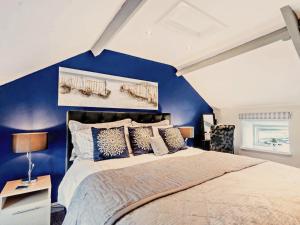 1 dormitorio con paredes azules y 1 cama grande en 1 Bed in Porthcawl 42314 en Brynmenin