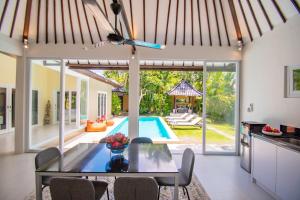 a kitchen and dining room with a table and a pool at Sitara Villa in Seminyak