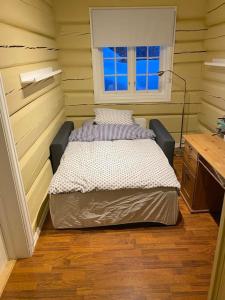 een slaapkamer met een bed in een kamer met een raam bij Tømmerhus nær Tusenfryd utenfor Oslo. in Ås