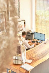 a man sitting at a desk with a computer at Hotel Boutique Bon Repos - Adults Only in Santa Ponsa