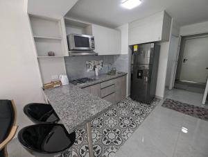 a small kitchen with a counter and a refrigerator at Lindo apartamento en el centro in Cali +8 photos