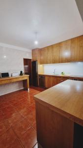 cocina grande con armarios de madera y encimera en Retiro do Viajante en Penacova