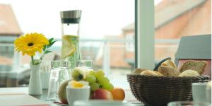 uma mesa com uma tigela de pão e uma cesta de frutas em Müritzperle em Waren