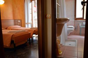 Habitación con 2 camas y baño con lavabo. en Hotel Corallo en Moneglia