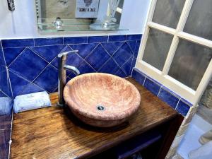 a bathroom sink with a wooden counter top at La Maison De Blanche Neige in Assignan